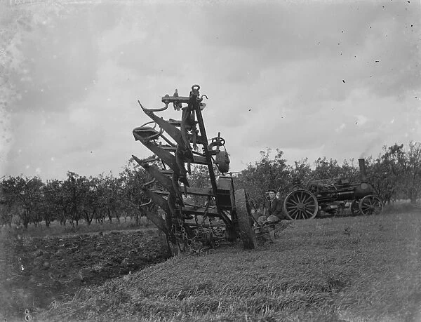 A farmer uses a steam engine to plough a field. 1935