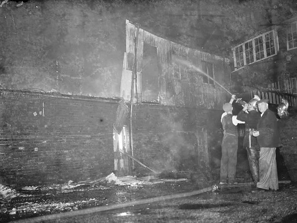 Fire, Halls, Dartford. Firemen dampening down the burnt - out building