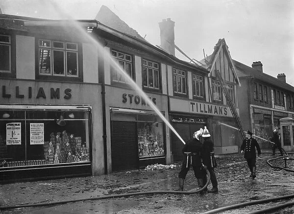 Firemen attempt to put out fires in a parade of shops in Welling, Kent