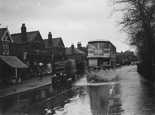 Flooded streets in Sidcup, Kent. Double dekker bus plows through the water