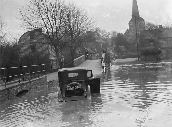 Flooding in Eynsford, Kent. Motorist tries to navigate through the flooded street