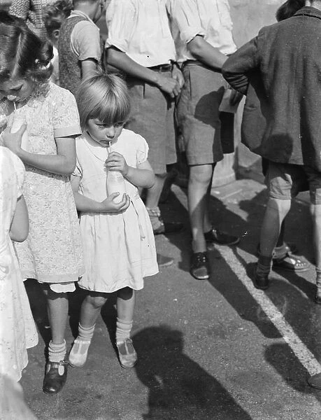 Free milk for children on holiday in Crayford, Kent. A little girl sips her milk