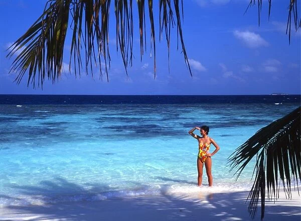 Girl standing on beach of the island of Bandos, in the Maldives