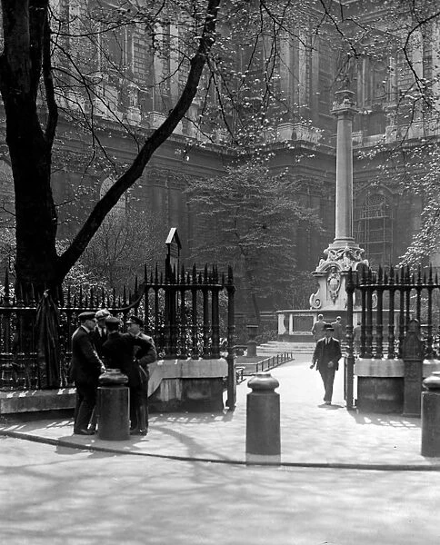 A group of men chat outside St Pauls Cathedral by Saint Pauls Church Yard