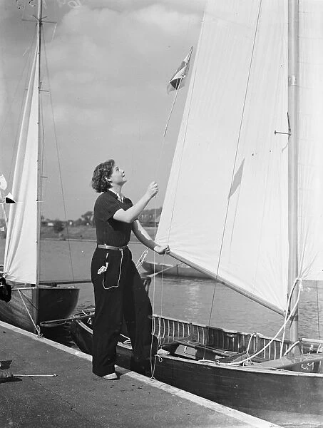 Hoisting the flag!. Yachting girl, Miss Peggy Masters, wasting the burgee (pennant
