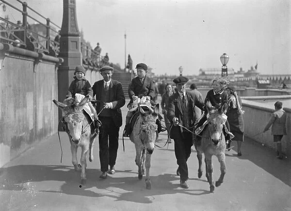 Holiday fun at Brighton. Children enjoying donkey rides in the sunshine at Brighton