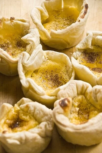 Home made portuguese style custard tarts with confectioners custard and puff pastry credit
