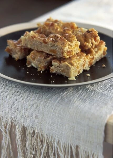 Homemade flapjack cookie bars arranged on brown plate credit: Marie-Louise Avery