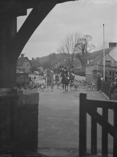 The huntsmen and their hounds follow the scent down the road. 31 January1938