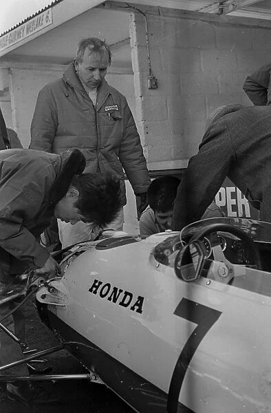 Japanese mechanics working on the suspension of John Surtees Honda car during testing