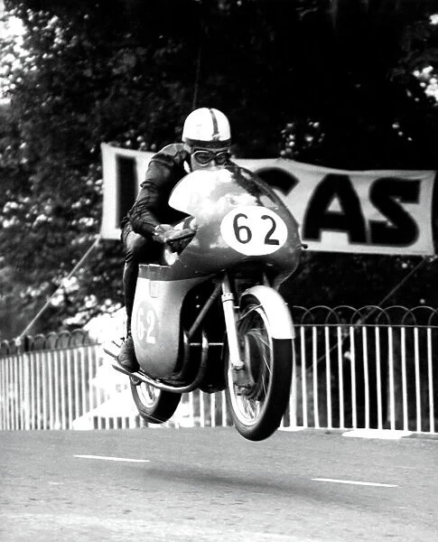 John Surtees MV machine is clear of the ground as he roars over Ballaugh Bridge