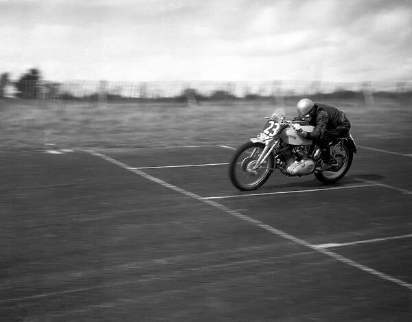 John Surtees speeds over the finishing line at the race track on his Vincent motorbike