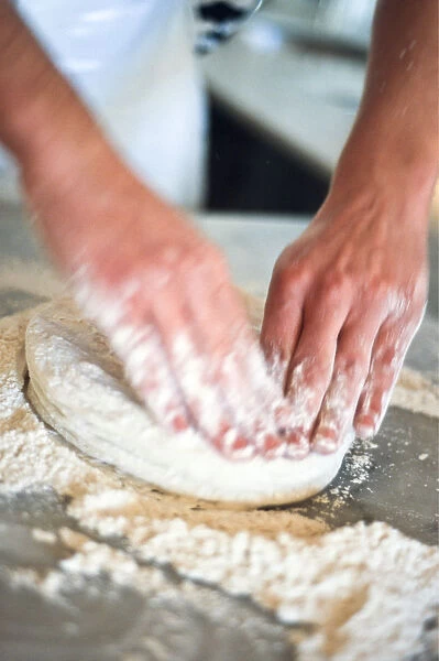 Kneading pizza dough on stainless steel surface. credit: Marie-Louise Avery  /  thePictureKitchen