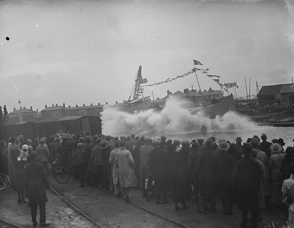 Large waves as a ship is launched broadside down the slipway at Faversham, Kent