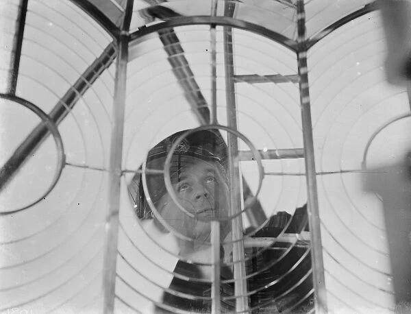 A lighthouse keeper checks the Dungeness lighthouse lantern glass in the lantern room