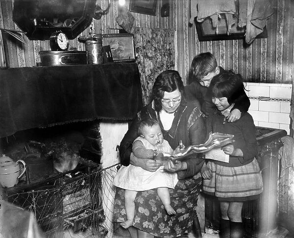Living conditions in the slums of the East End. Mrs Livesey with her baby and two