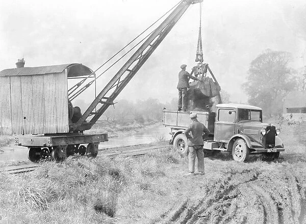 Loading sand into a lorry with a crane. 1935