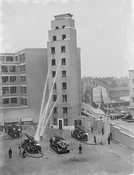 A London Fire Brigade display in Lambeth, London. Firemen hose down from the windows