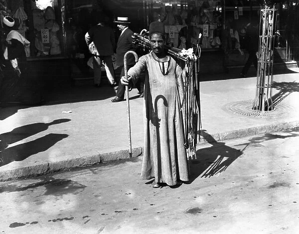 A man selling walking sticks on the streets of Cairo, Egypt. 21 March 1923