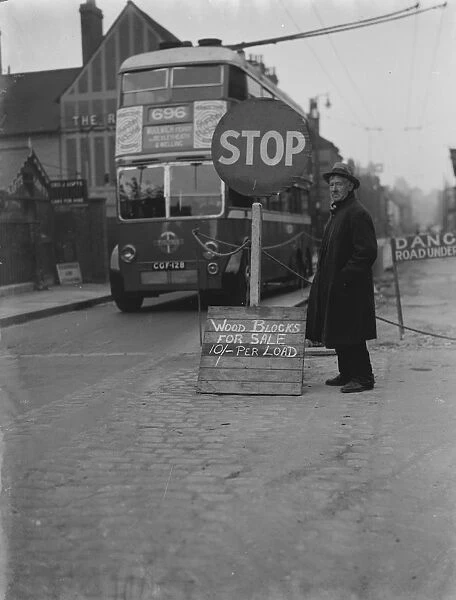 A man with a wood blocks for sale sign on side of the road in Dartford, Kent