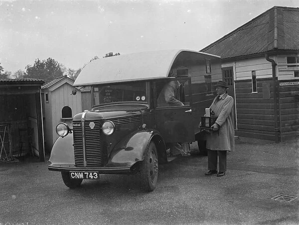 Men carrying the totalisators from a Bedford truck at Hurst Park Racecourse in Molesey