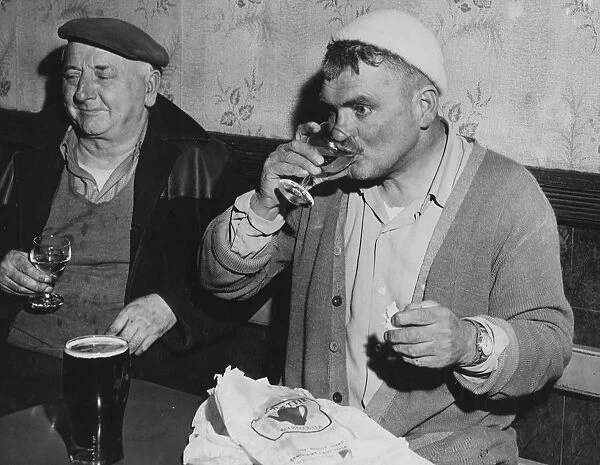 Men of Harlech taste the wine and wash away the taste with a pint of beer. Gwynedd, North Wales