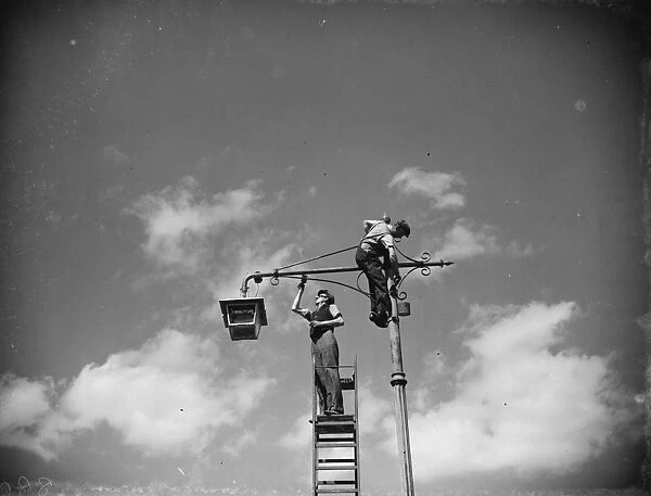 Men painting lamp a standard in Sidcup, Kent. 1938