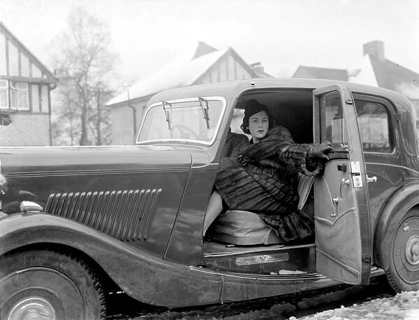 Miss Muriel Oxford sitting in the passenger seat of a car at the side of the road. 1937