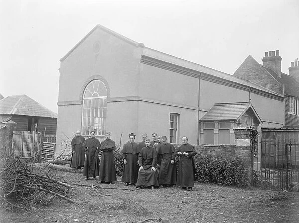 Monks building feat. Hall and part Church erected by Brother Raymond ( sitting )