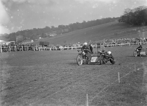 Motor cycling races at Brands Hatch. Two of the side car bikes jostle for position