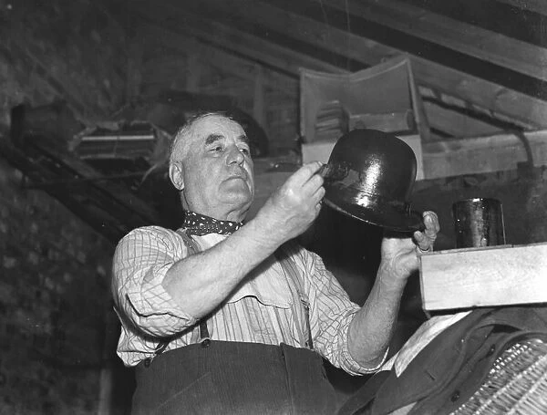 Mr Charlie Hever painting tar onto a bowler hat in Eynsford, Kent. 1937