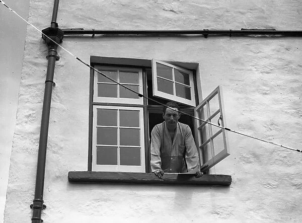 Mr Compton Mackenzie looking out of the window of his island home on Jethou, Channel Islands