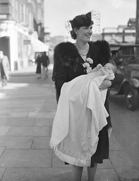 Mrs C G F Pritchett holds her infant son after the babys christening at St Pauls Church
