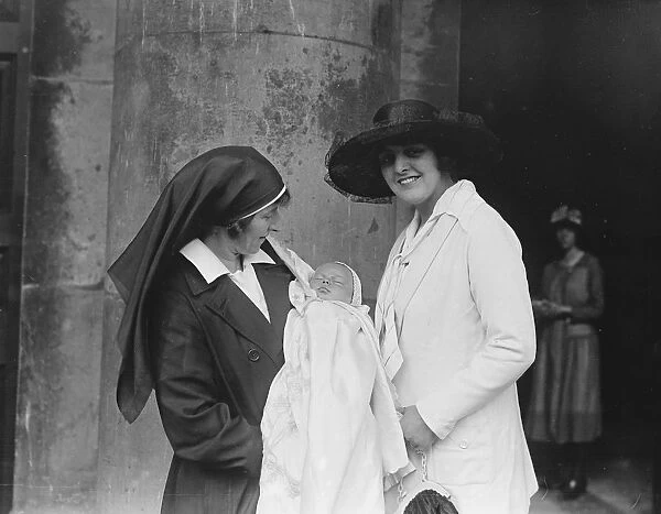 A nurse holds the son of actor Lupino Lane at his christening at St Georges Church