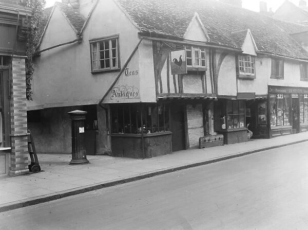 The old cock house shop at Eton, showing the old stocks and pillar box of years ago