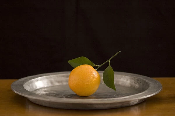 Orange with leaves on pewter charger credit: Marie-Louise Avery  /  thePictureKitchen