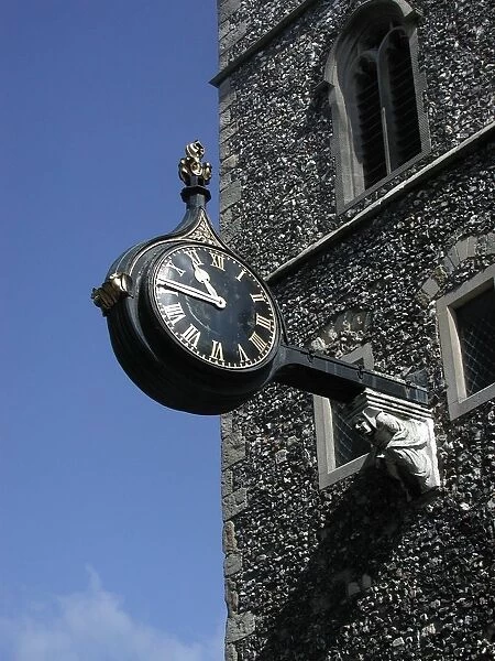 Ornate clock on a wall bracket on the facade of a church, Canterbury, Kent, England