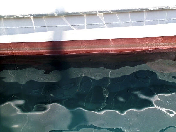 Detail of painted boat at water line showing reflections and ripples credit: Marie-Louise