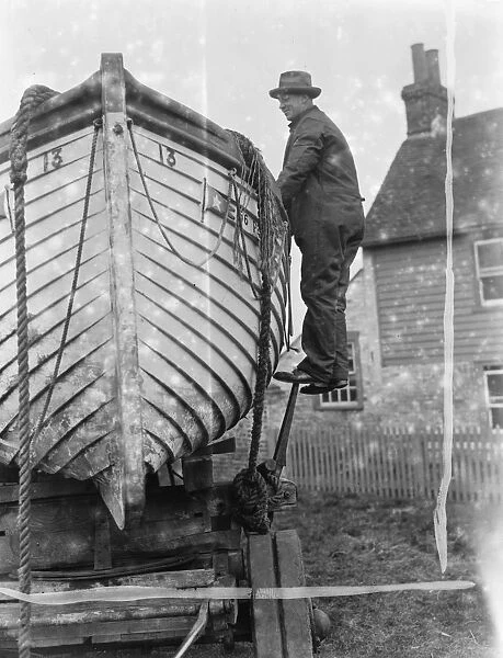 A policeman builds a boat on the village green in Faversham, Kent. 1937