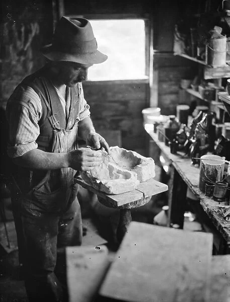 Pottery maker Mr Sadler filling sides of a rabbit mould with clay. 1938
