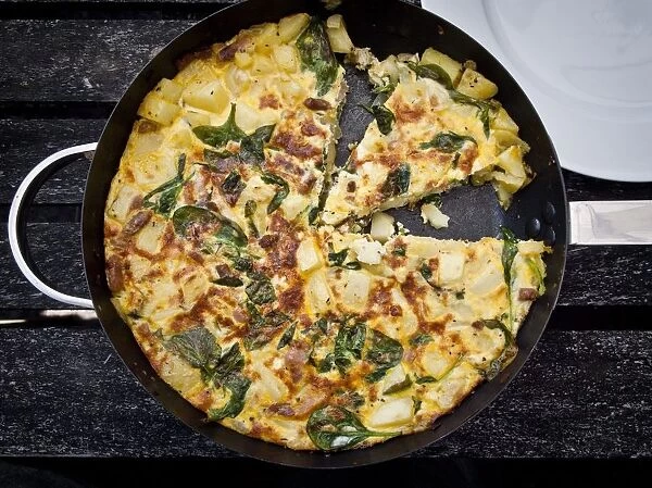 Prawn and spinach frittata with aluminium foil being wrapped fro a picnic