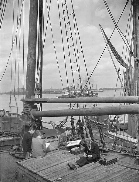 Pupils from the art school sit on the deck of a Thames Barge drawing pictures in