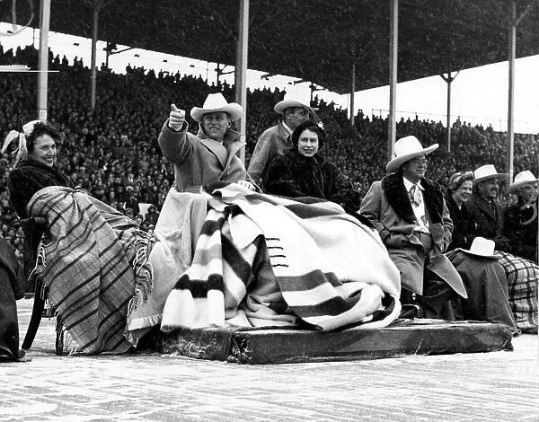 Queen Elizabeth II wearing a blanket ( a wedding present from Canada) and the Duke