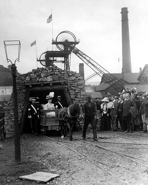 Queen Mary is led out of a coal mine by a miner and pit pony during a Royal visit