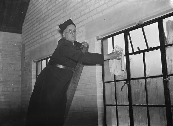 The Reverend M Cox cleaning windows in Swanscombe, Kent. 1937