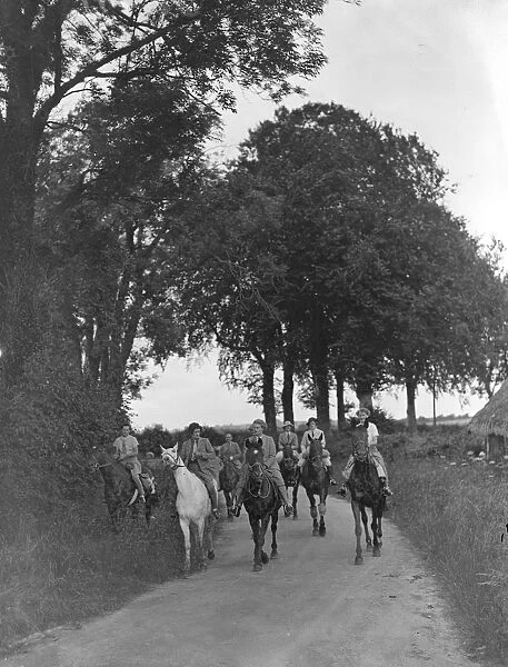 Riders of the Garth Pony Club team, passing through a tree-lined country lane