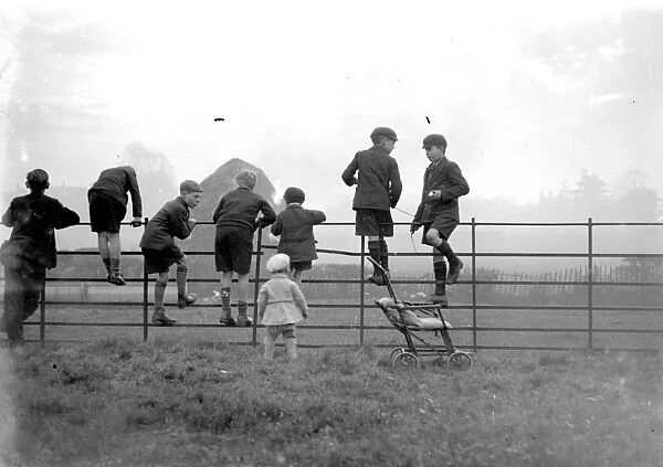 Schoolboys playing on a fence in the country. 1933