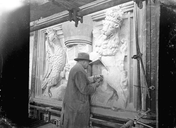 A sculptor working on a heraldic base relief [Royal Supporters of England  /  Royal Arms of England