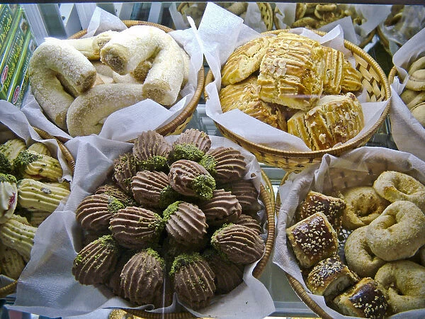 Selection of cakes, cookies and biscuits in display case of patisserie cafe in resort