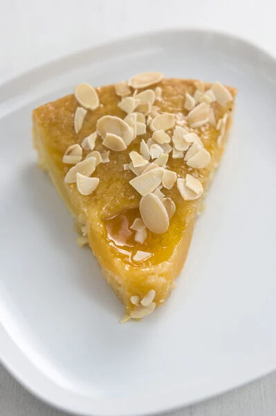 Slice of peach cake  /  tart sprinkled with flaked almonds credit: Marie-Louise Avery